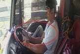 Tài xế dùng chân điều khiển xe đầu kéo chạy trên cao tốc, tay cầm điện thoại lướt TikTok